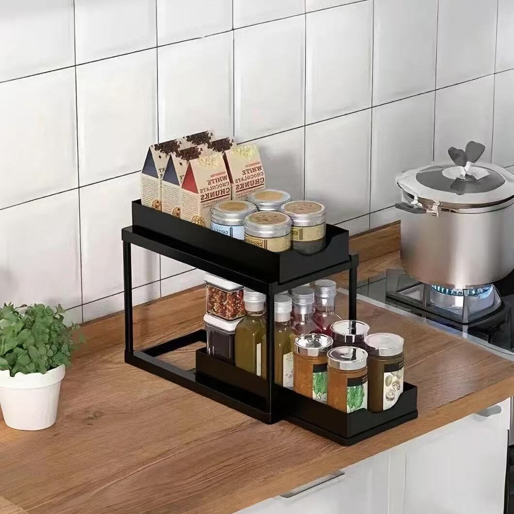 Two-tier pull-out storage rack. An organizational lifesaver for under the kitchen sink. Features adjustable shelves for easy storage of bottles and jars. In a sleek, modern design. Perfect as a kitchen shelf, bathroom organizer, or household storage solut